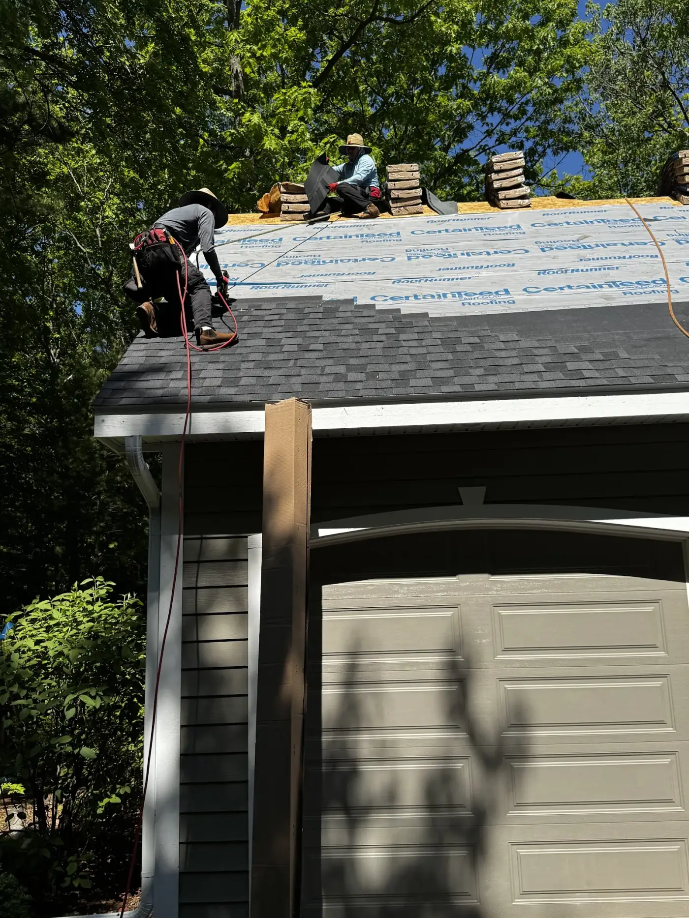 Falcon's crew laying architectural shingles on a garage roof near Traverse City.