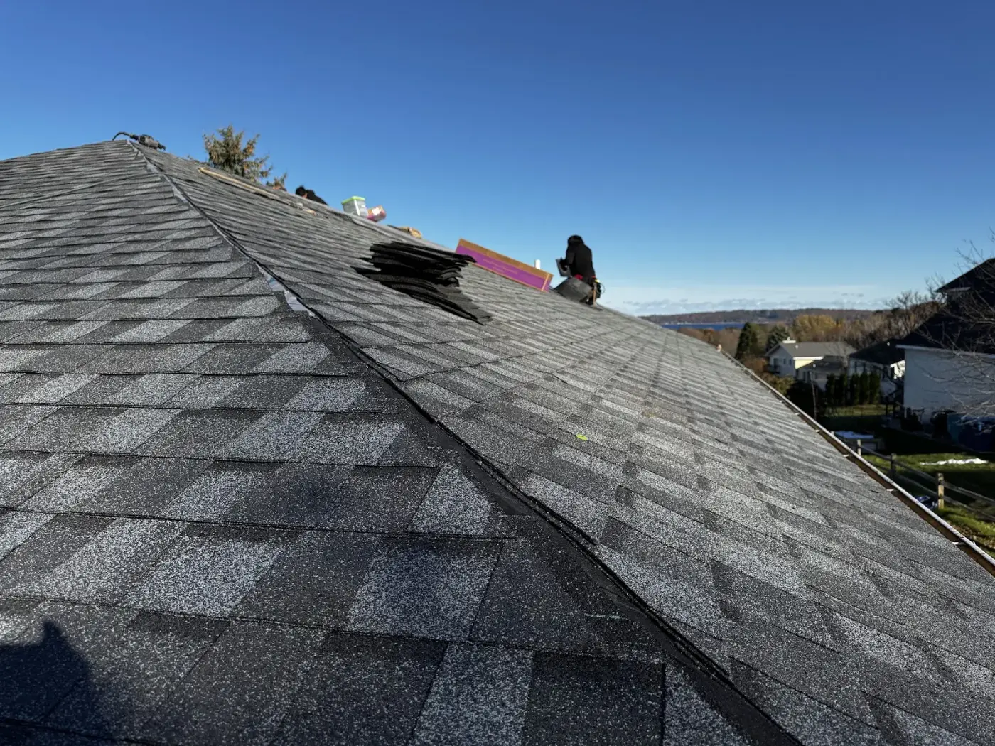 Architectural asphalt shingles going down, the value benchmark homeowners weigh metal against.