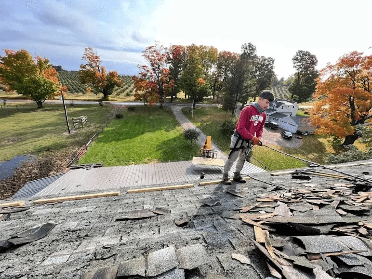 Old asphalt shingles being torn off a Northern Michigan home during roof replacement