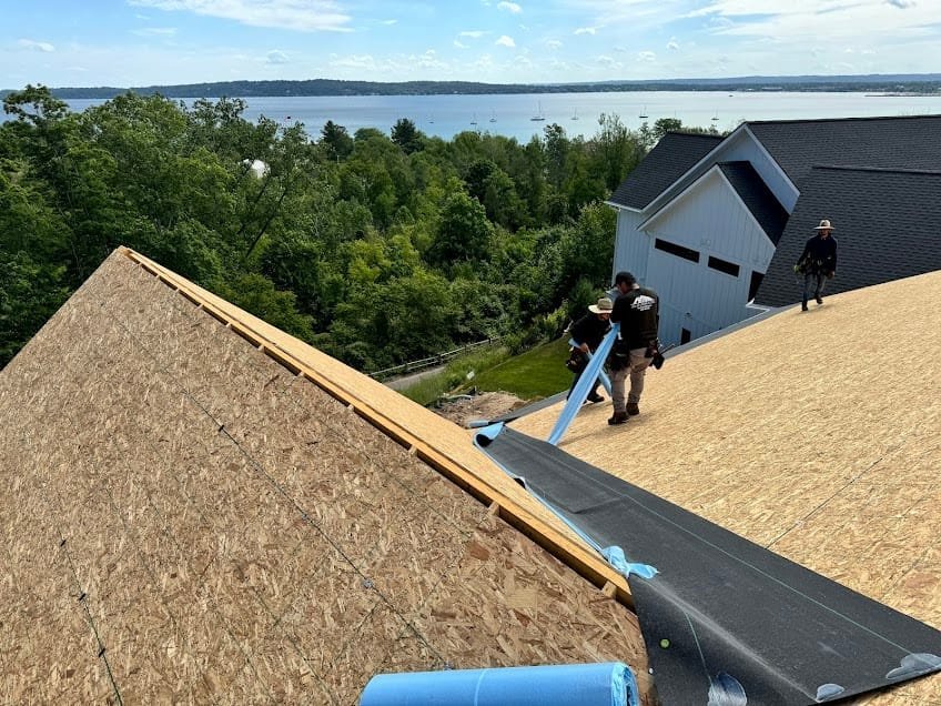 Falcon Roofing crew installing roofing on a waterfront home in Northern Michigan